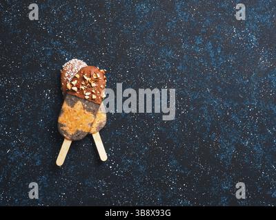 Chia ghiaccioli a crudo con la torta di carote e cioccolato su sfondo blu scuro. Ricetta sana e idea vegano fatti in casa ghiaccioli gelati. Pasqua id dessert Foto Stock