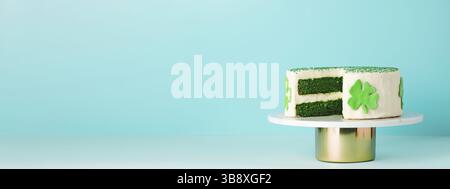 Il giorno di San Patrizio, il concetto di cibo dolce. Torta di velluto verde decorato foglie di shamrock verde per la festa di San Patrizio su sfondo blu. Spazio di copia. Lo Foto Stock