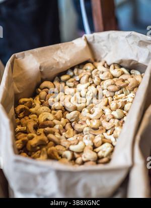 Anacardi in un sacchetto di carta in vendita Foto Stock