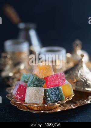 Caffè turco con delizia e tradizionale servizio di rame su sfondo scuro. Caffè turco tradizionale assortito dilight o lokum e turco in Foto Stock