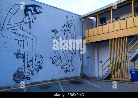 Lungo un vicolo dietro un vecchio appartamento a Mount Pleasant, Vancouver, con un murale sul lato. Foto Stock