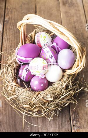 Varie viola le uova nel paniere, decorazioni di Pasqua Foto Stock