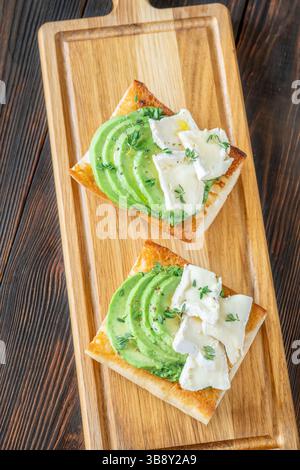 Panini tostati con ciabatta a strati di brie, avocado e spinaci cremosi, erbe aromatiche delicate Foto Stock