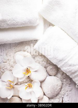 Sale marino, rebbles con orchidee e asciugamani bianchi, spa concept Foto Stock
