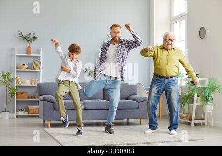 Una famiglia di uomini che si divertono in salotto, ballano e si divertono insieme. Foto Stock