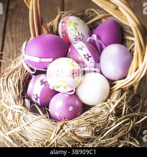 Varie viola le uova nel paniere, decorazioni di Pasqua Foto Stock