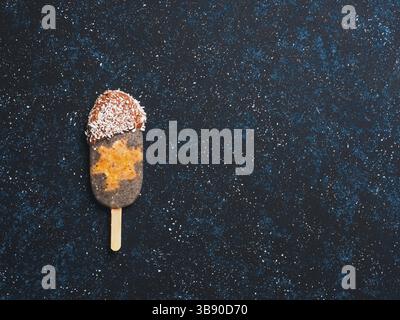 Chia ghiaccioli a crudo con la torta di carote e cioccolato su sfondo blu scuro. Ricetta sana e idea vegano fatti in casa ghiaccioli gelati. Pasqua id dessert Foto Stock