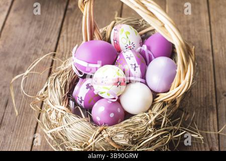 Varie viola le uova nel paniere, decorazioni di Pasqua Foto Stock