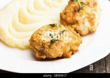 Cotolette di pollo e purè di patate in una piastra da vicino Foto Stock