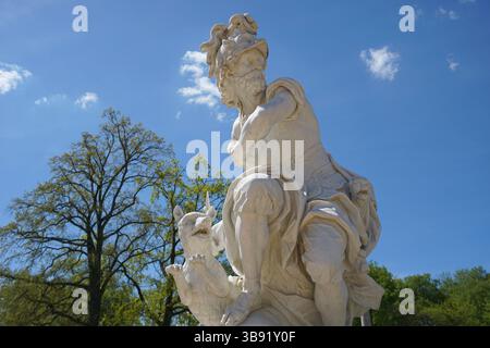 Una statua in marmo di Marte o Ares, l'antico dio della guerra romano/greco, con un cane si erge nel parco giardino del castello di Palazzo Sanssouci, Potsdam, Germania Foto Stock