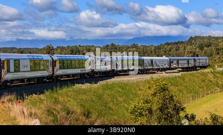 Nuova Zelanda tranzalpine carrozze livate di mondi viaggio in treno grande attraversano il bellissimo paesaggio delle alpi meridionali prendendo da una vista all'aria aperta Foto Stock