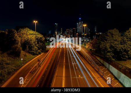 Lunga esposizione di percorsi leggeri per auto e dello skyline di Leeds di notte, creando una vivace scena urbana Foto Stock
