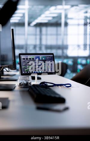 Codice in esecuzione su schermi di computer e tablet nello spazio di lavoro vuoto del data center utilizzato per la risoluzione dei problemi di montaggio su rack. Script binario che funziona sui monitor dei PC desktop che aggiornano i sistemi mainframe nella sala server Foto Stock