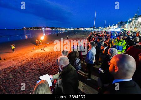 Weymouth, Dorset, Regno Unito. 8 maggio 2025. La grande folla che si è rivelata a guardare il faro acceso bruciare sulla spiaggia durante il servizio per il 80° anniversario del VE Day e l'illuminazione del faro a Weymouth nel Dorset, Regno Unito. Crediti fotografici: Graham Hunt/Alamy Live News Foto Stock