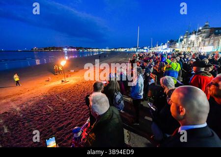 Weymouth, Dorset, Regno Unito. 8 maggio 2025. La grande folla che si è rivelata a guardare il faro acceso bruciare sulla spiaggia durante il servizio per il 80° anniversario del VE Day e l'illuminazione del faro a Weymouth nel Dorset, Regno Unito. Crediti fotografici: Graham Hunt/Alamy Live News Foto Stock