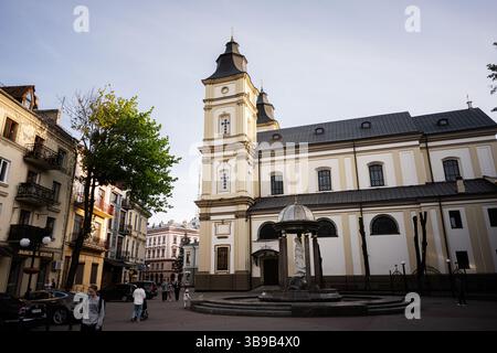 Ivano-Frankivsk, Ucraina - 29 aprile 2025: Vista panoramica di una cattedrale e degli edifici circostanti sotto un pittoresco cielo limpido. Foto Stock