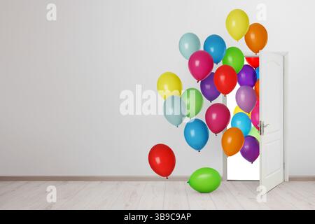 Molti palloncini brillanti volano a porte aperte. Decorazioni festive per feste di compleanno o altre celebrazioni Foto Stock