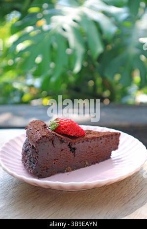 Una fetta di torta al cioccolato senza fiori umida e saporita con fragola fresca Foto Stock