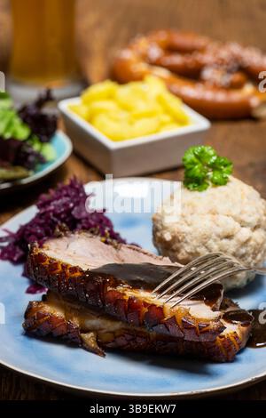 Porzione di maiale arrosto fresco su un piatto blu Foto Stock