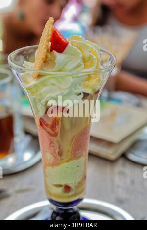 Deliziosi gelati con liquore all'uovo, fragole e panna Foto Stock