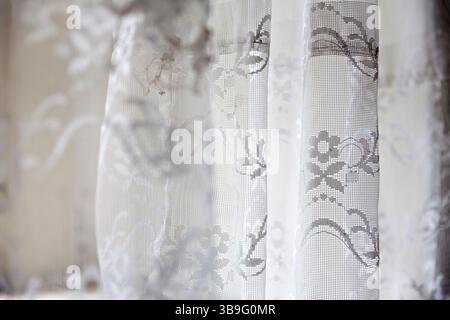 Vecchie tende sulla finestra di una casa abbandonata come sfondo Foto Stock