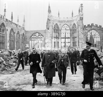Il primo ministro Winston Churchill cammina con il sindaco di Coventry e un membro del clero della Chiesa d'Inghilterra attraverso la navata in rovina della Cattedrale di Coventry dopo che è stata bombardata dall'aviazione tedesca nel novembre 1940. Foto Stock