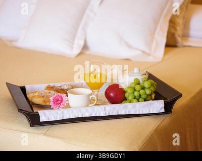 Deliziosa colazione a letto con frutta, caffè e pasticcini Foto Stock