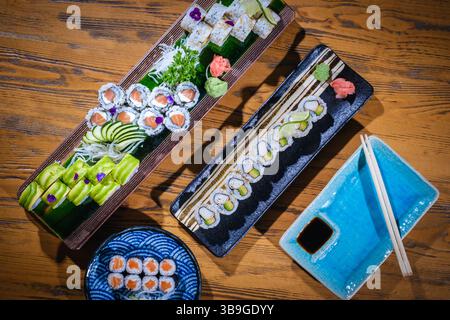Vista dall'alto di diversi sushi roll splendidamente disposti su piatti, che offrono una deliziosa esperienza culinaria giapponese Foto Stock