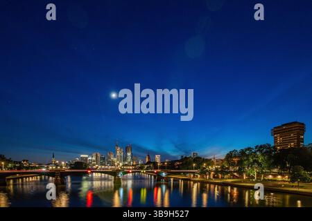 Vista dello skyline da un ponte. Metropoli con grattacieli riflessi in un fiume. Città di Francoforte sul meno, Germania Foto Stock