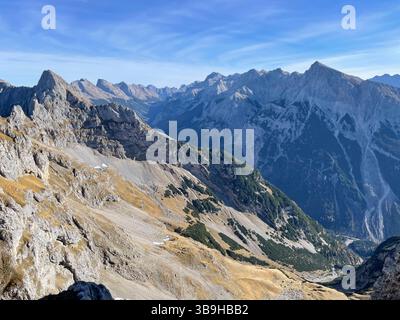 Vista sulla valle del Karwendel dalla ferrata Mittenwalder Höhenweg, sulle montagne del Karwendel, panorama, Karwendelspitze orientale, Pleisenspitze, panorama montano, autunno, natura, montagne, innumerevoli cime, attività, sole, nuvole, cielo blu, tour in montagna, Alpenwelt Karwendel, Karwendel Nature Park, Werdenfelser Land, Mittenwald, alta Baviera, Baviera, Germania Foto Stock