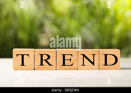 Word Trend in cubi di legno con lettere sul tavolo all'aperto Foto Stock