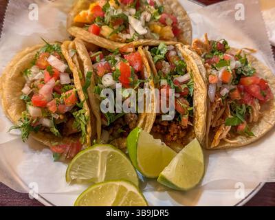 Un piatto colorato di autentici tacos da strada condito con pico de gallo fresco e servito con spicchi di lime, perfetto per Cinco de Mayo, Taco Tuesday Foto Stock