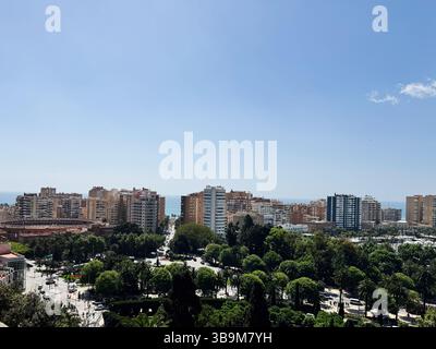 Malaga, Spagna - 2 maggio 2025: Una giornata di sole a Malaga, Spagna, con edifici, vegetazione e la costa mediterranea Foto Stock