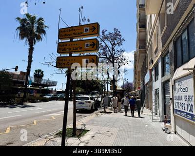 Malaga, Spagna - 2 maggio 2025: Strada urbana di Malaga con indicazioni stradali per gli hotel locali sotto la luce del sole Foto Stock
