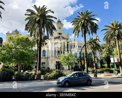 Malaga, Spagna - 2 maggio 2025: Architettura storica del municipio con palme in una giornata di sole a Malaga, Spagna Foto Stock