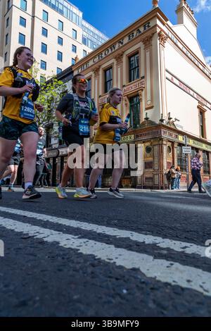 I corridori della maratona di Belfast corrono davanti al famoso Crown Bar di Belfast. Foto Stock