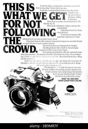 Questo annuncio del 1982 per la fotocamera Minolta XG-M sottolinea l'innovazione rispetto alla conformità, vantando caratteristiche come l'esposizione automatica, l'azionamento del motore e gli obiettivi intercambiabili. Mette in evidenza la reputazione di Minolta per la precisione, la facilità d'uso e le prestazioni di livello professionale in una reflex consumer-friendly. La tipografia audace rafforza lo slogan: “Questo è ciò che otteniamo per non seguire la folla”. Foto Stock