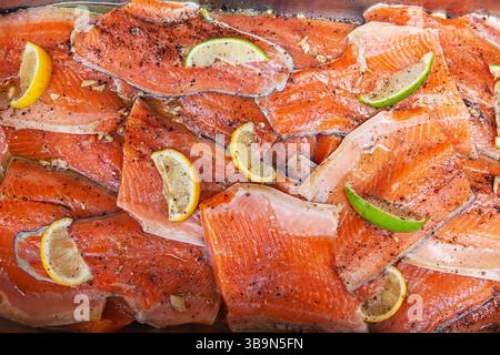 Filetti di pesce rosso con pezzi di limone e lime sulla parte superiore. Foto Stock