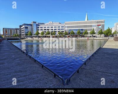 Vista sul porto delle barche, negozi e ristoranti a più piani del centro città, negozi, nuovi edifici, architettura, riflessi sull'acqua, promenad Foto Stock