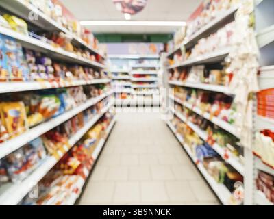Abstract supermercato sfocata corsia con ripiani colorati e i clienti non riconoscibile come sfondo Foto Stock