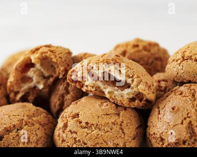 Pila di amaretti con biscotti su fondo in marmo bianco - tradizionale pasticceria italiana sarda. Biscotti amaretti a base di mandorle o albicocche Foto Stock