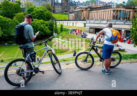 Persone che si godono il caldo sole primaverile nei Princes Street Gardens di Edimburgo, Scozia Foto Stock