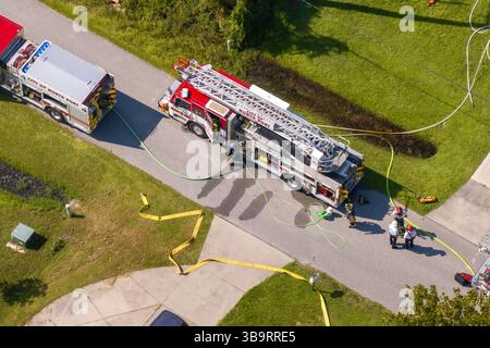 Soccorritori che indagano sul rischio di incendio di abitazioni private. Personale di servizio di emergenza che risponde a un incidente di monossido di carbonio in Florida residenziale Foto Stock