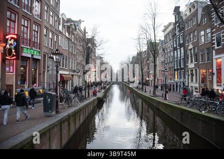 Paesi Bassi, Amsterdam, 13 febbraio 2025: Canale che si estende lungo il quartiere a luci rosse De Wallen di notte ad Amsterdam Paesi Bassi Foto Stock