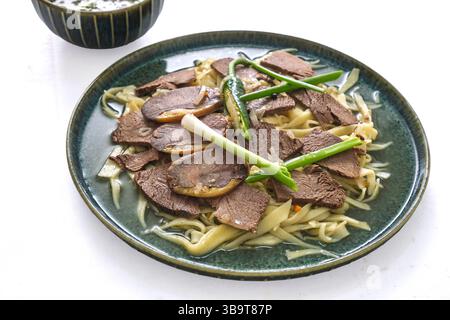 Il Beshbarmak è un piatto nazionale dell'Asia centrale: Carne di cavallo bollita, spaghetti, verdure e una ciotola di brodo caldo. Foto Stock