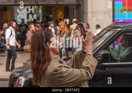 LONDRA - 8 MAGGIO 2025: Una donna che scatta una foto selfie con il suo cellulare a Oxford Street, nel centro di Londra Foto Stock