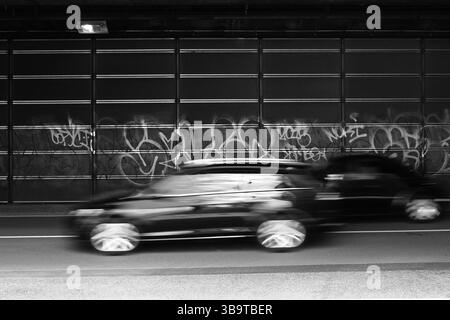 Scene di tutti i giorni in Japan Cars che sfrecciano lungo il bypass sotto il cavalcavia e sporchi graffiti che sono stati dipinti più e più volte Foto Stock