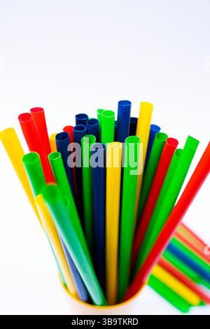 Cannucce luminose e allegre per bevande disposte in verticale in un contenitore. Foto Stock