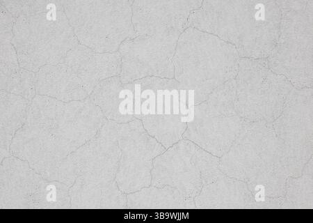 Incrinature nelle pareti dopo l'intonacatura e la verniciatura. Sfondo con struttura in cemento incrinato. Intonaco verniciato di bianco con sottili incrinature in un edificio W Foto Stock