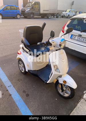Cremona, Italia - 5 aprile 2025 Uno straordinario scooter White Mobility con comodi posti a sedere parcheggiati sulla strada che offre libertà e accessibilità per Foto Stock